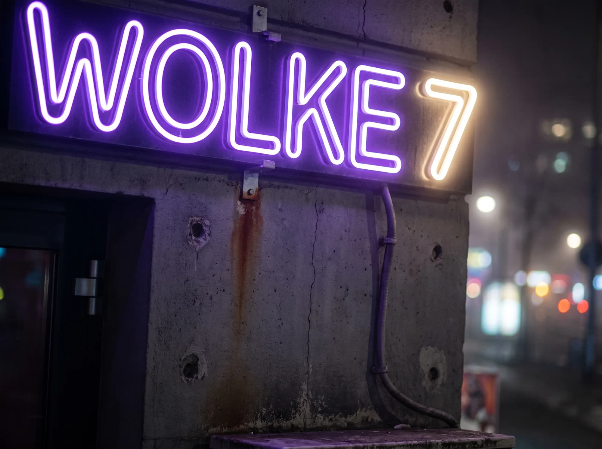Violetter Neon-Schriftzug an einer Betonwand neben dem Eingang einer Shisha-Bar